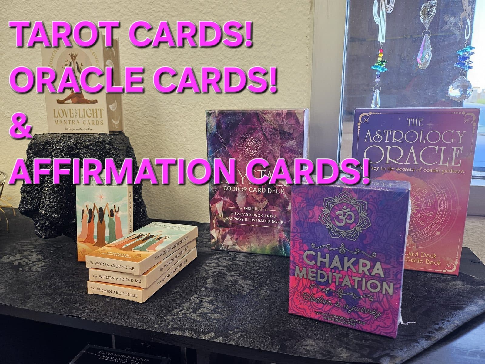 Tarot, oracle and affirmation decks standing on a black table, captioned “Tarot cards! Oracle cards! & Affirmation cards!”.